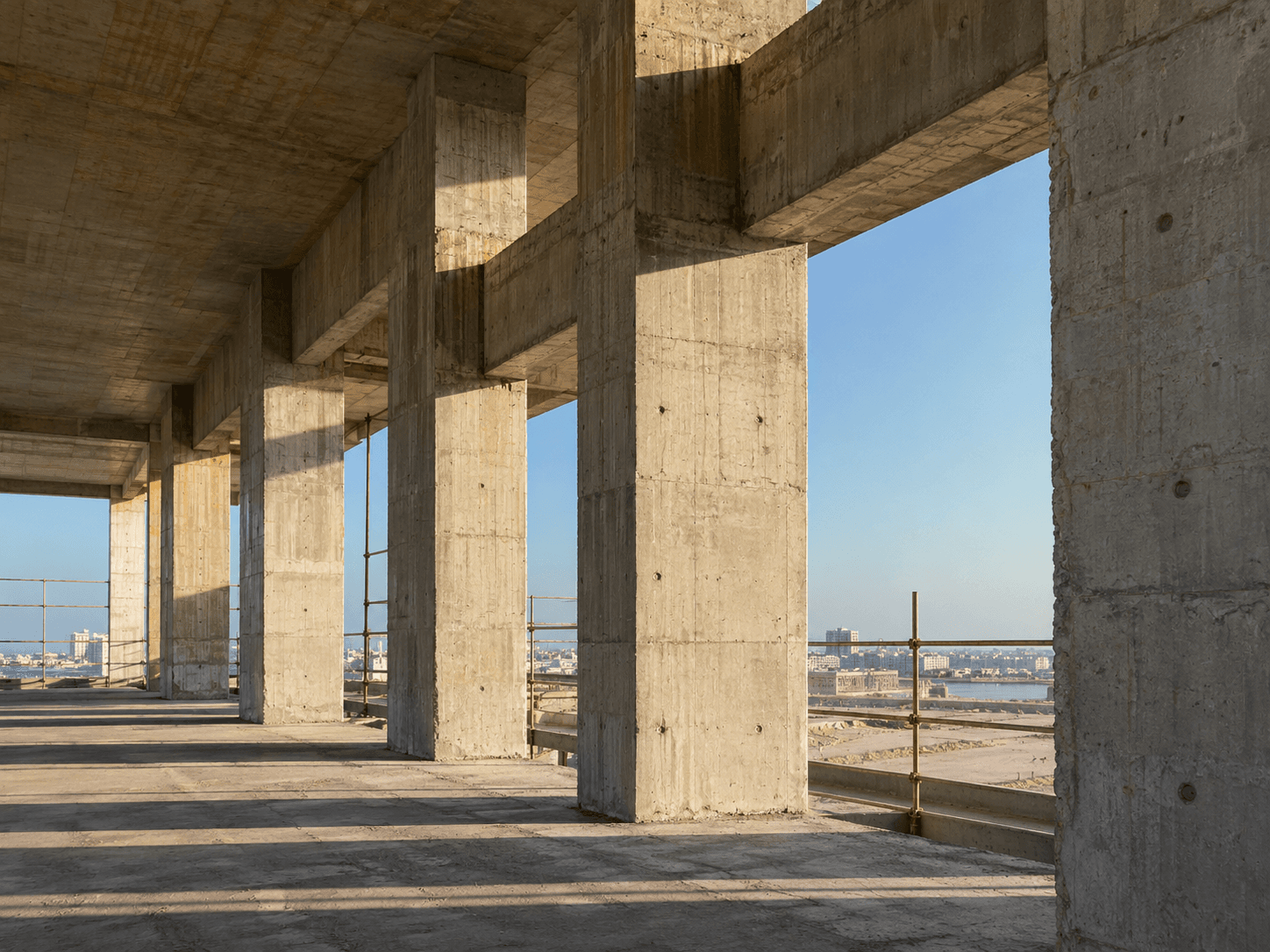 تصور معماري لأعمدة وجسور خرسانية مضاءة بالشمس داخل هيكل مفتوح.